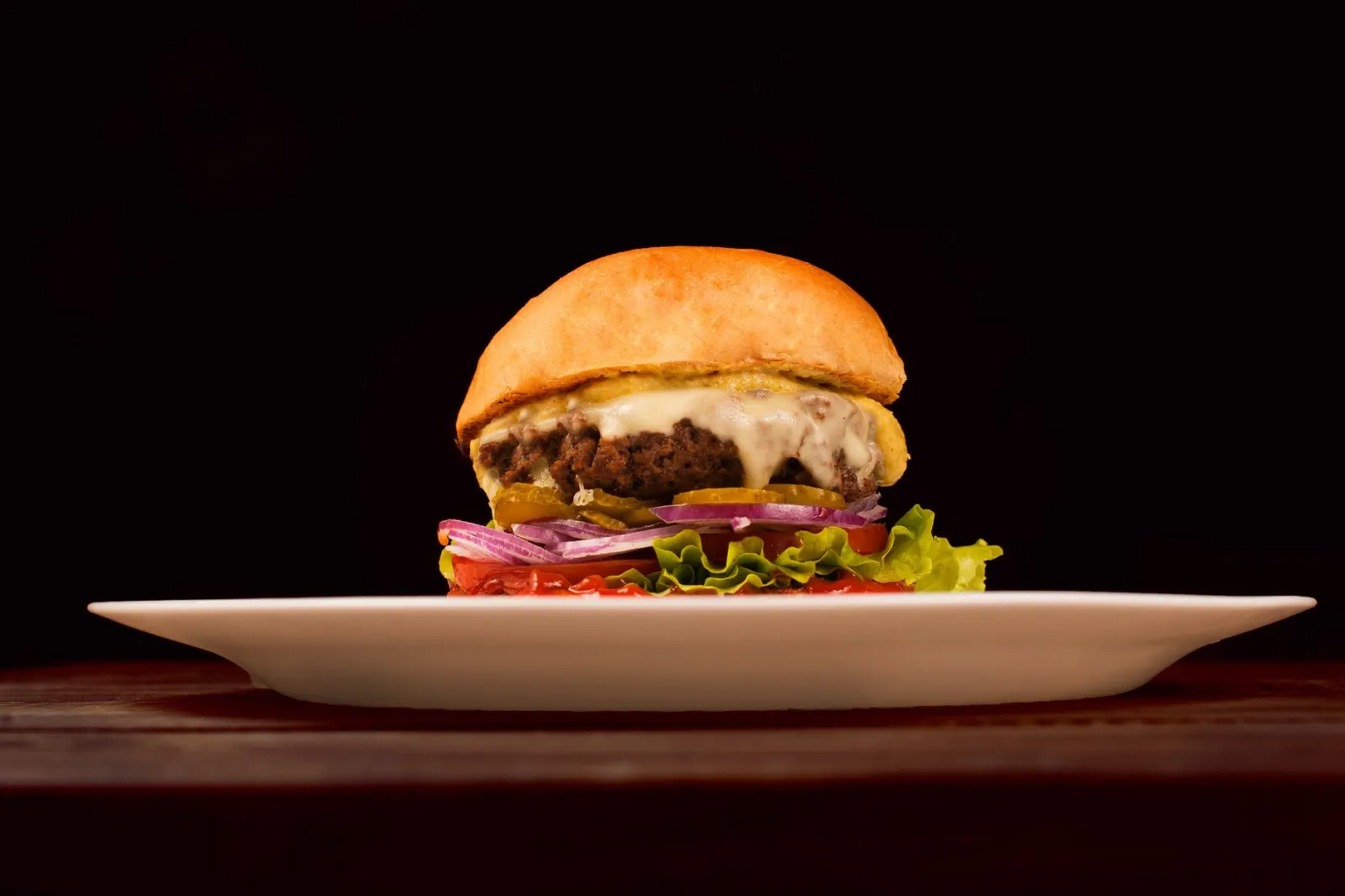Klasyczny cheeseburger na talerzu z roztopionym serem