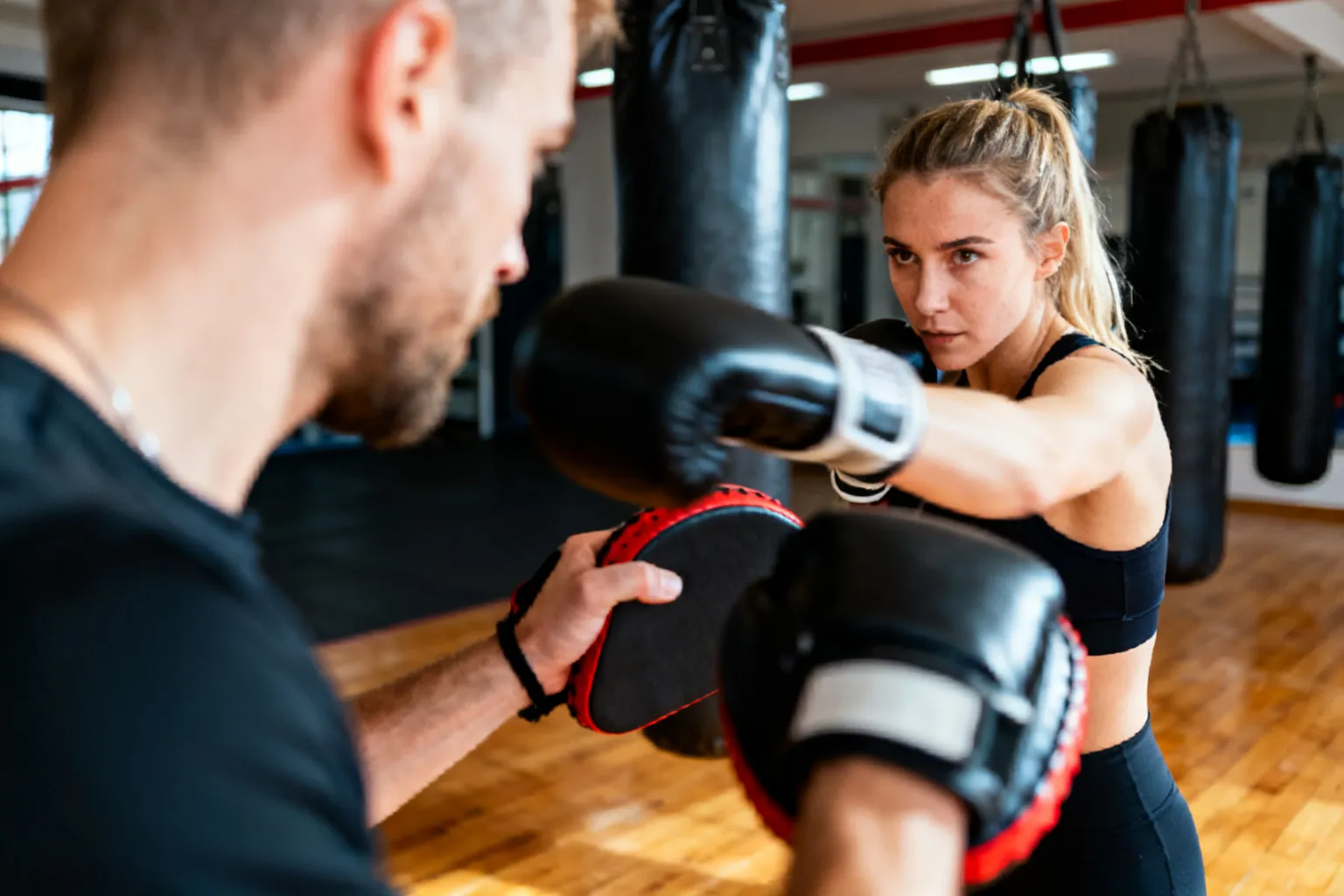 Sesja bokserska: trener i zawodniczka podczas pracy na padach