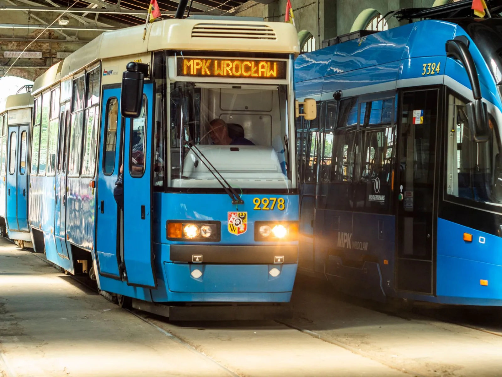 Nowoczesny tramwaj w hali obsługi, technik przy pojeździe