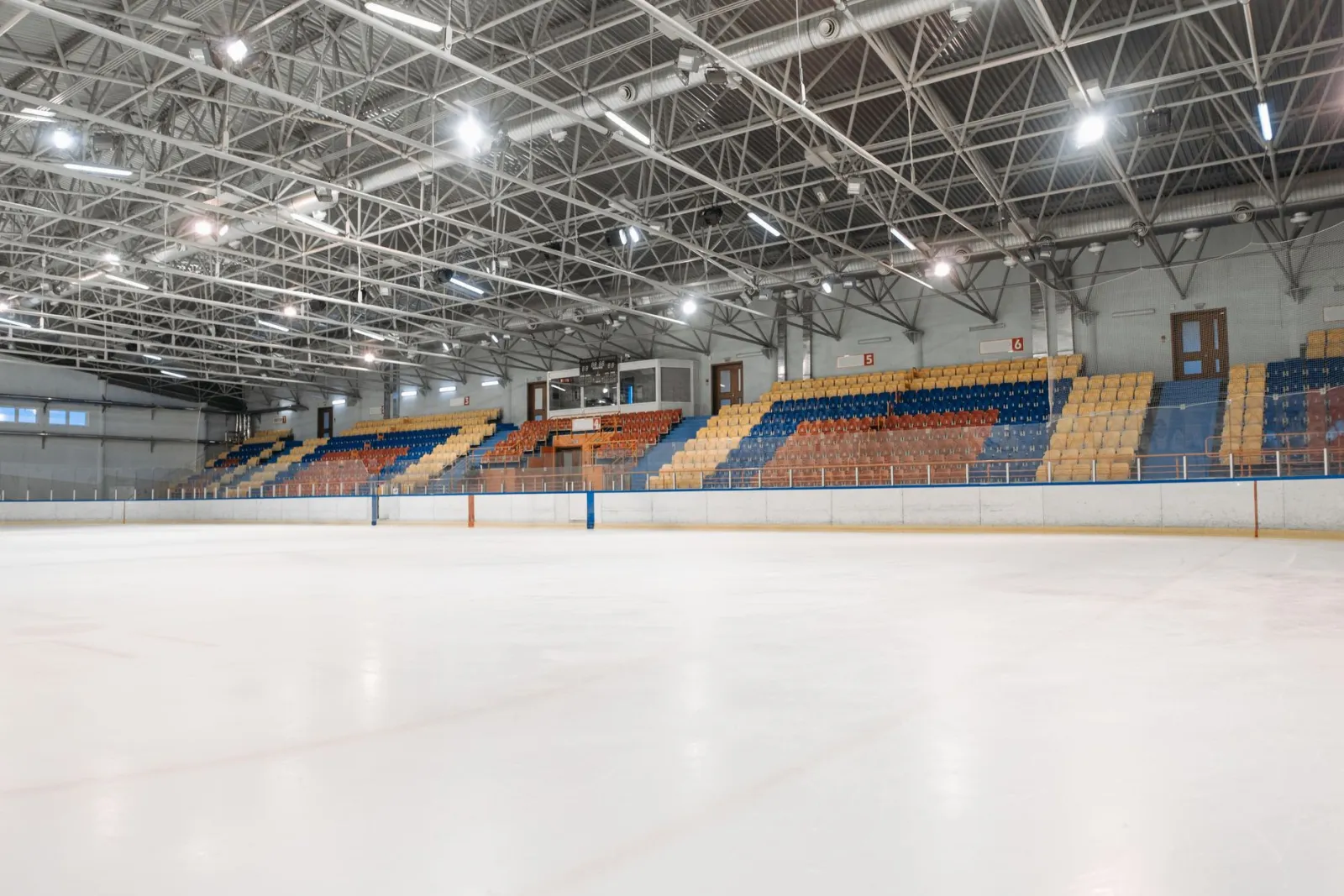 Wnętrze nowoczesnej hali sportowej z trybunami i pustymi siedzeniami